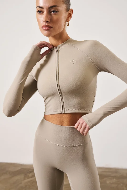 SCULPTING EMBLEM ZIP THROUGH TOP - BEIGE